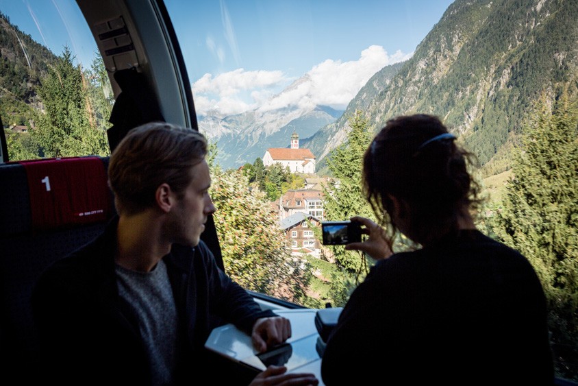 Treinreis in een panoramawagon van de Gotthard-Panorama-Expess van Lugano naar Flüelen. Uitzicht op het kerkje bij Wassen. De trein rijdt hier door een aantal keertunnels.
